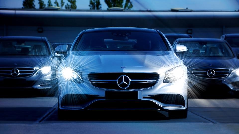 Cars parked with their headlights on at dusk