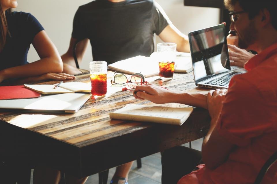 People reviewing paperwork and a laptop together at a table