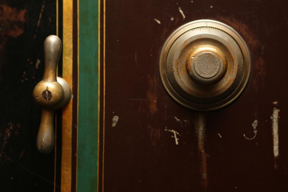 Close-up of an old safe door with a combination dial