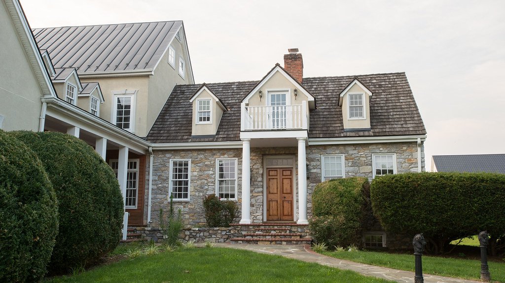 A stone-front suburban home with a landscaped walkway
