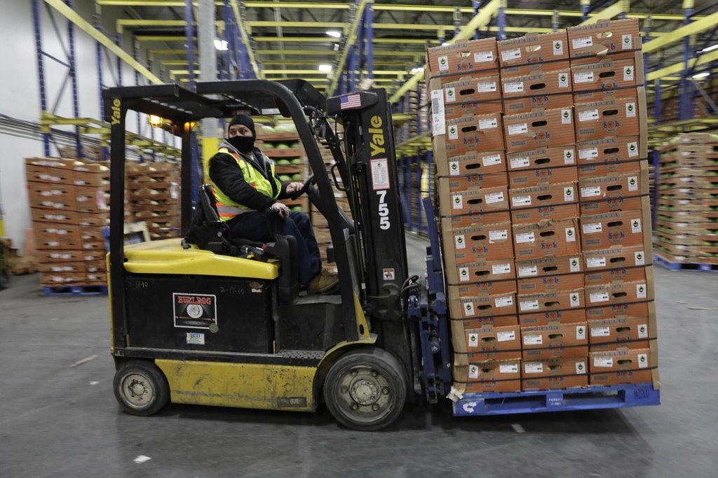A forklift moving palletized freight inside a warehouse