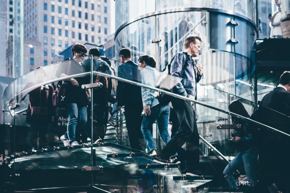 People on a glass staircase in a city office building
